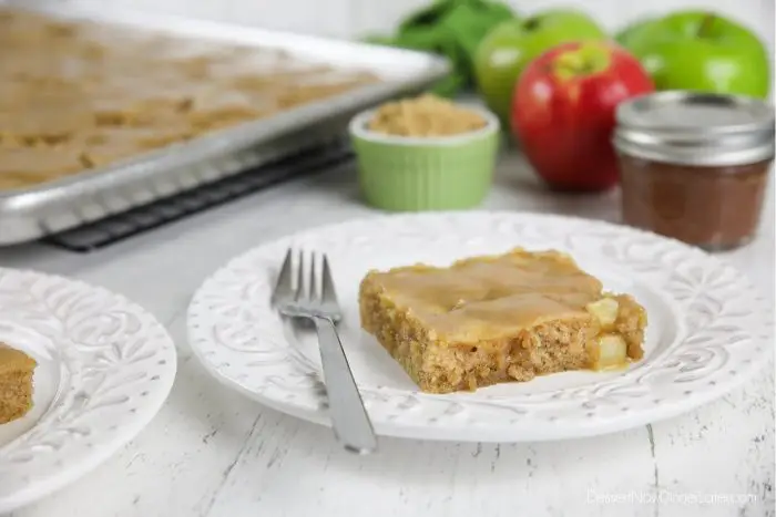 Slice of apple sheet cake on plate with fork.