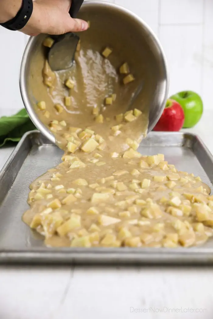 Apple cake batter being poured into sheet pan.