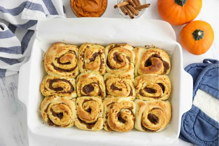 Pumpkin cinnamon rolls in pan after being baked.