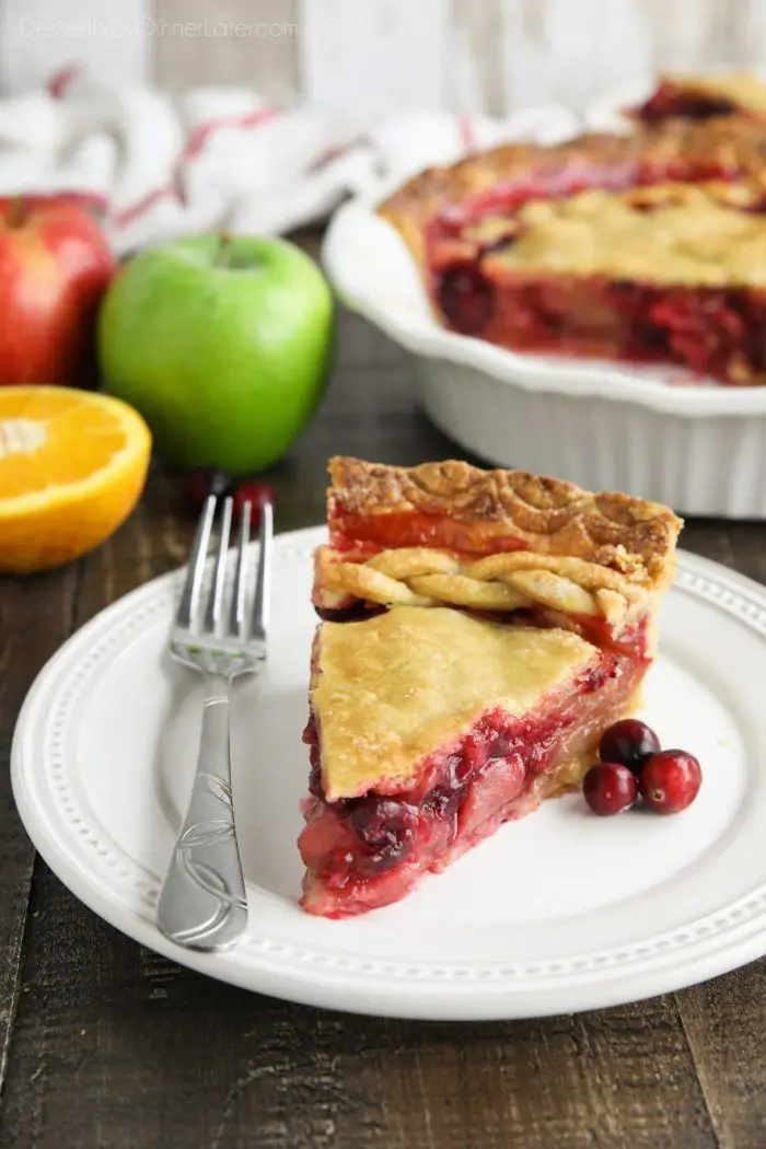 Slice of cranberry apple pie on plate with fork.