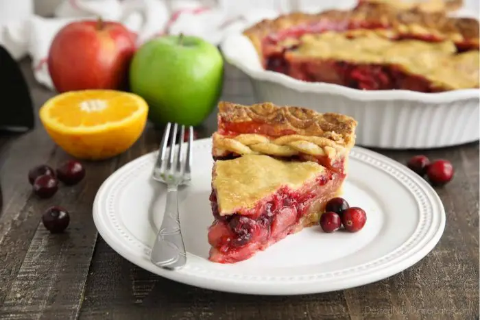 Slice of cranberry apple pie on plate with fork.