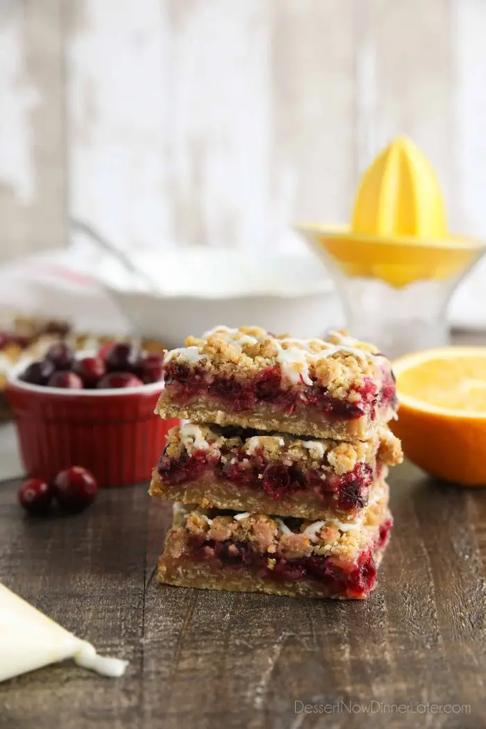 Side view of cranberry crumble bars stacked on top of each other.