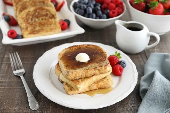 Stacked French toast with butter and syrup.