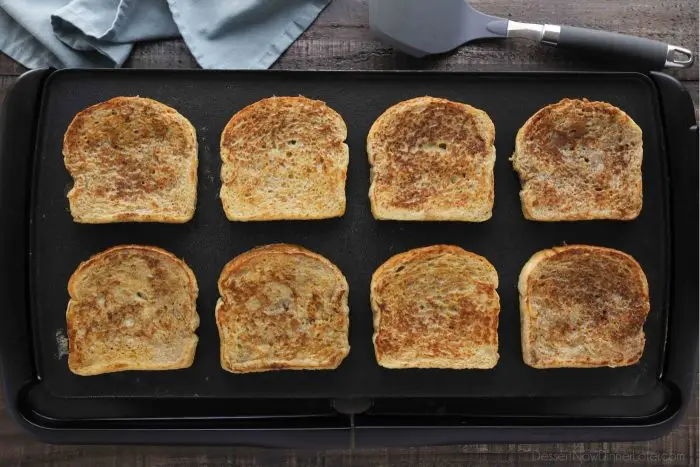 Classic French toast being cooked on a griddle.