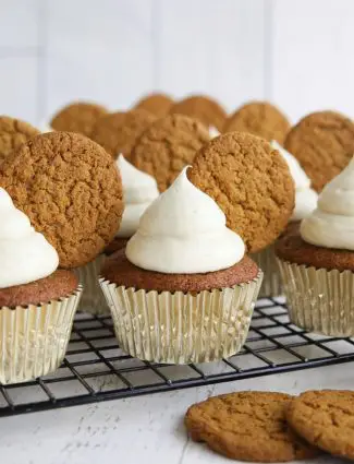 Gingerbread cupcakes with cream cheese frosting and a gingersnap cookies on top.