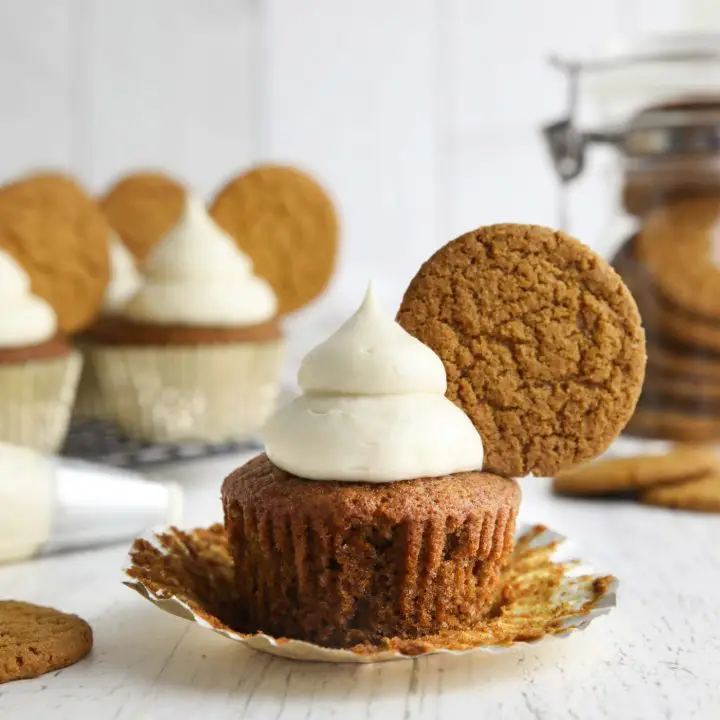 Spiced gingerbread cupcake with cream cheese frosting and a gingersnap cookie on top.