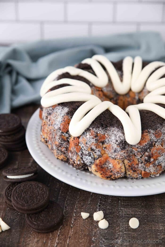 Angled view of Cookies and Cream Monkey Bread on a plate with zig-zagged cream cheese frosting on top.