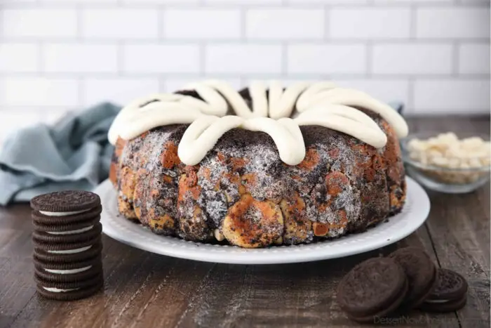 Front view of Cookies and Cream Monkey Bread on a plate with zig-zagged cream cheese frosting on top.