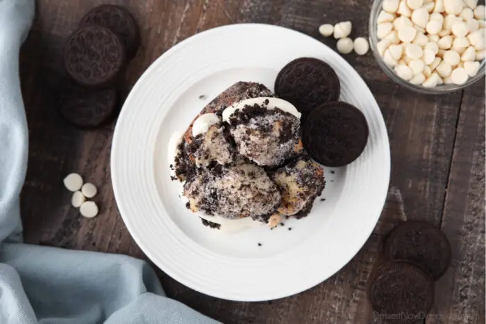 Top view of Oreo monkey bread pull apart on plate with cream cheese frosting and Oreo cookies.