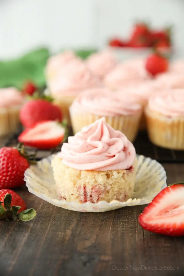 Strawberry cupcake in wrapper with strawberry buttercream on top.