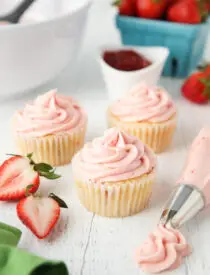 Strawberry frosting piped onto cupcakes.