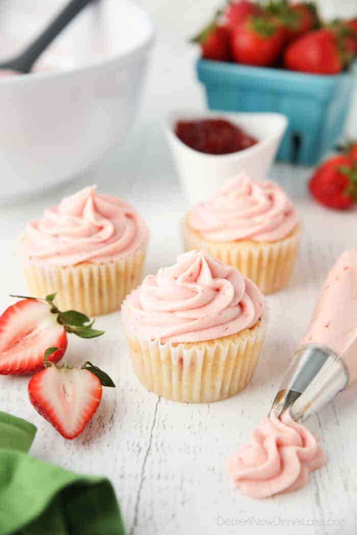 Strawberry frosting piped onto cupcakes.