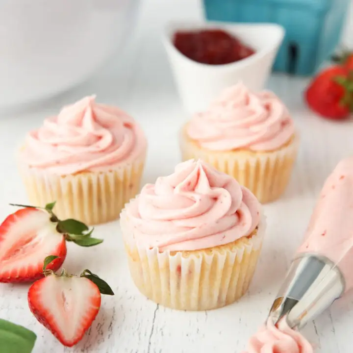 Strawberry frosting piped onto cupcakes.