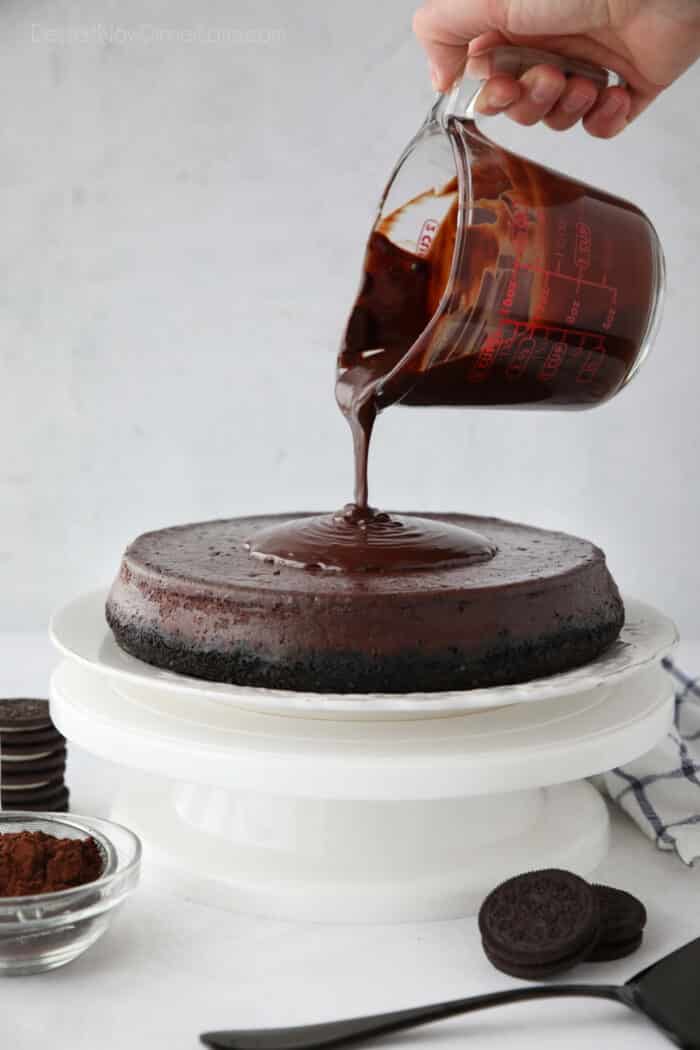 Pouring ganache on top of chocolate cheesecake.