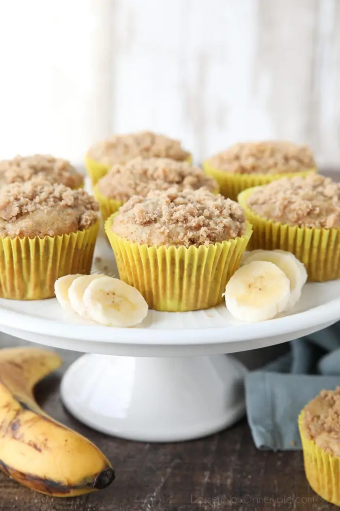 Cake plate with banana crumb muffins and slices of bananas.
