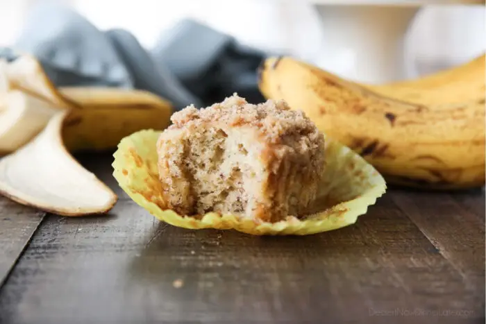 Side view of a banana crumb muffin with a bite taken out.