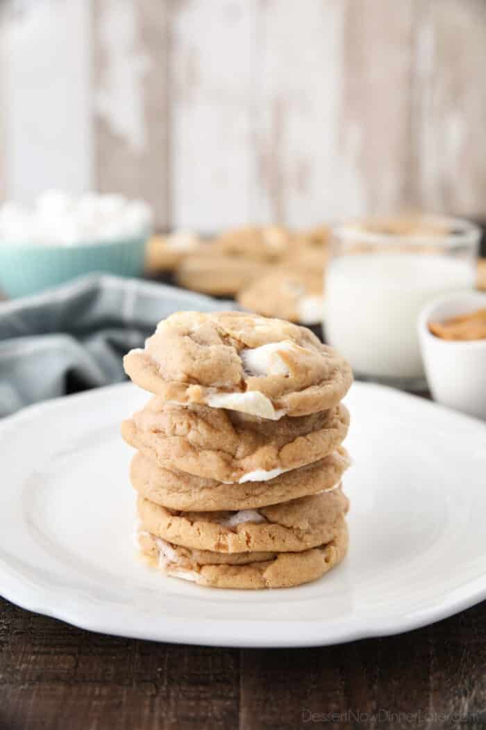 Stack of peanut butter marshmallow cookies on a plate and a glass of milk in the background.