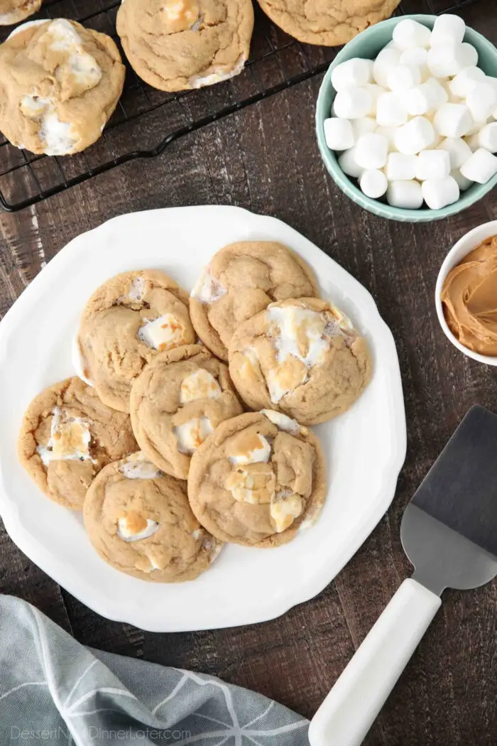 Peanut butter cookies with mini marshmallows on a plate and a cookie spatula next to it.
