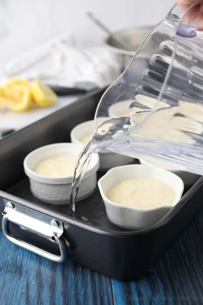 Pouring water into roasting pan around lemon pudding cakes.