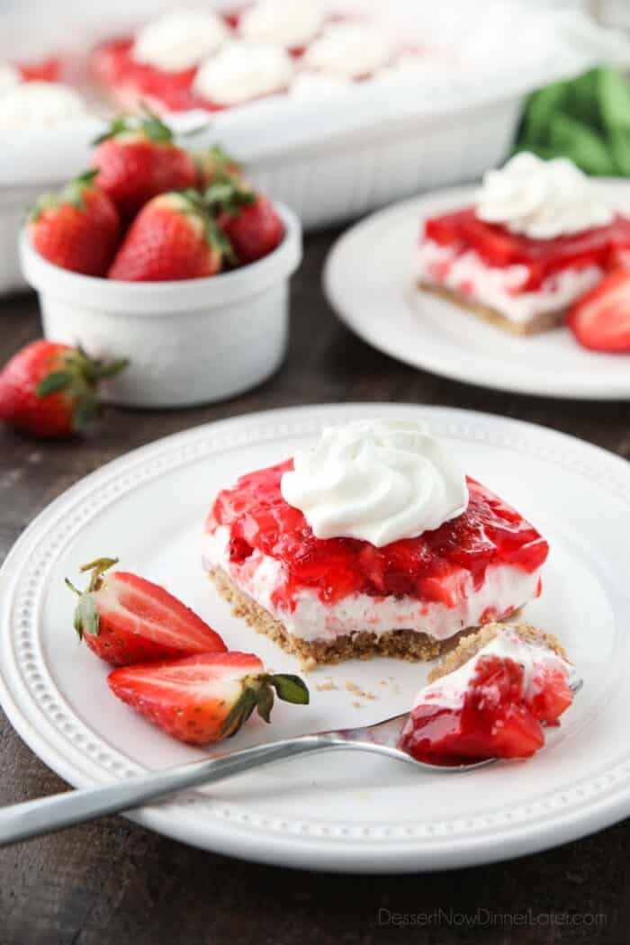 A serving of strawberry delight on a plate with a fork-full taken out.