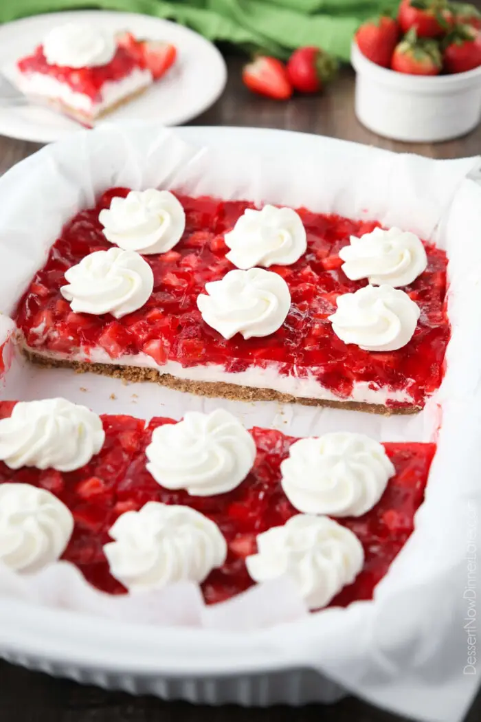 13x9-inch dish of strawberry delight with swirls of whipped cream on each square piece.