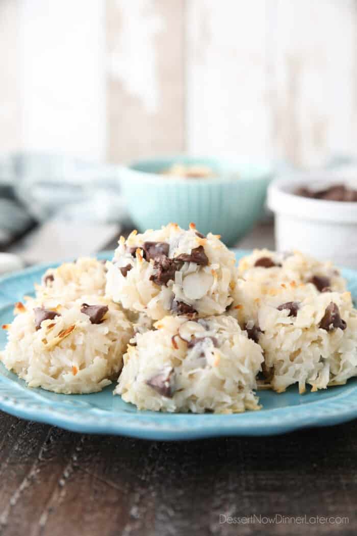 Side view of a plate of coconut macaroons with almonds and chocolate chips.