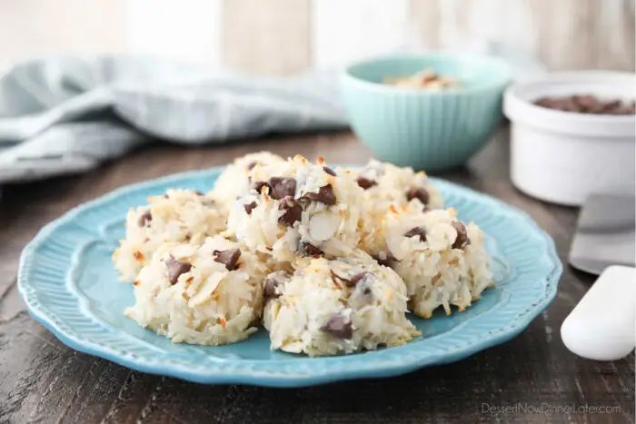 Side view of a plate of coconut macaroons with almonds and chocolate chips.