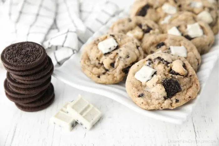 Plate of cookies and cream cookies with a stack of Oreos and a broken up cookie & cream candy bar on the side.