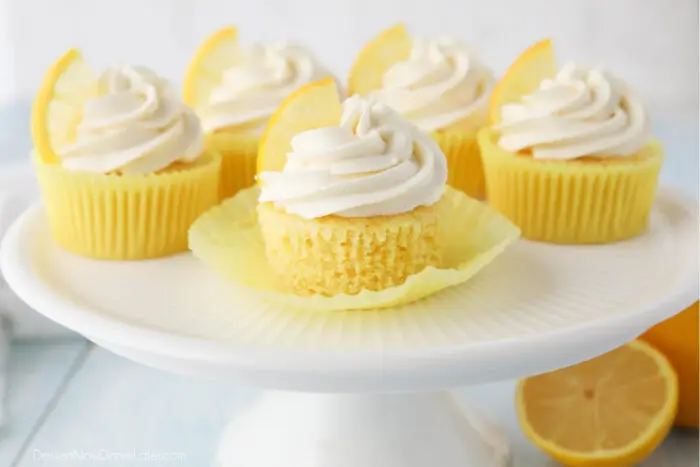 Cake plate full of lemon cupcakes with cream cheese frosting.