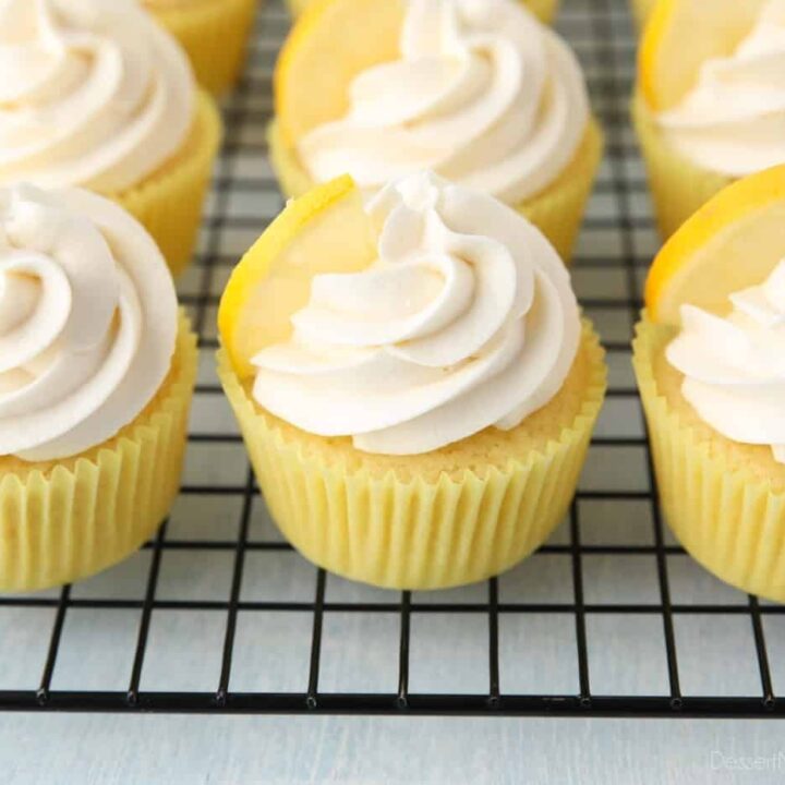 Cooling rack full of frosted lemon cupcakes.