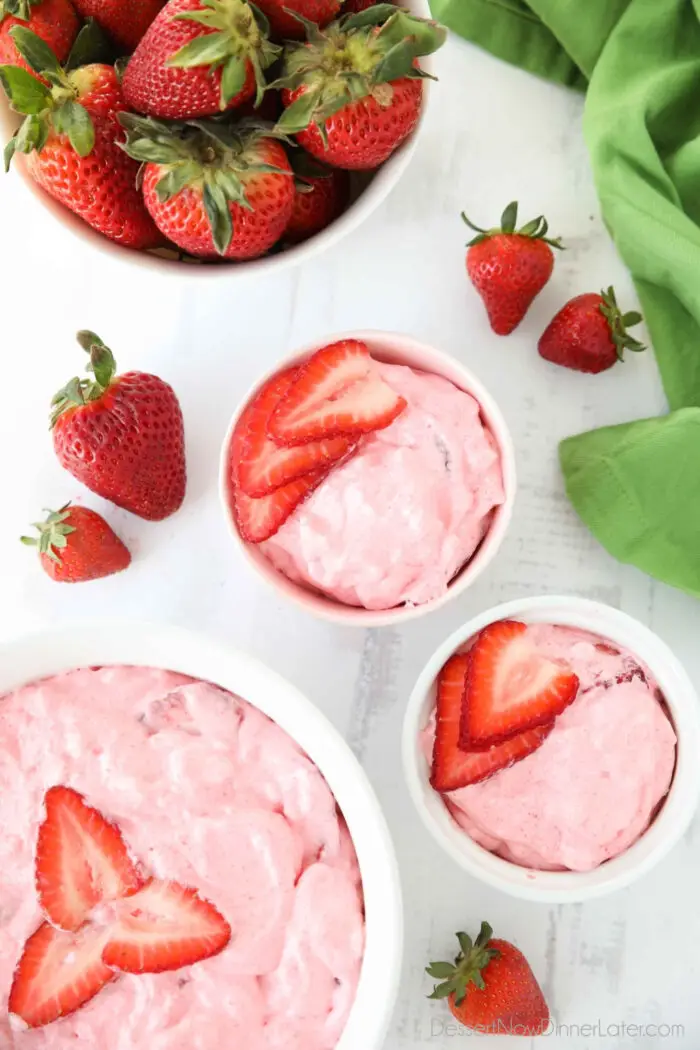 Top view of three bowls of strawberry fluff with sliced strawberries on top.