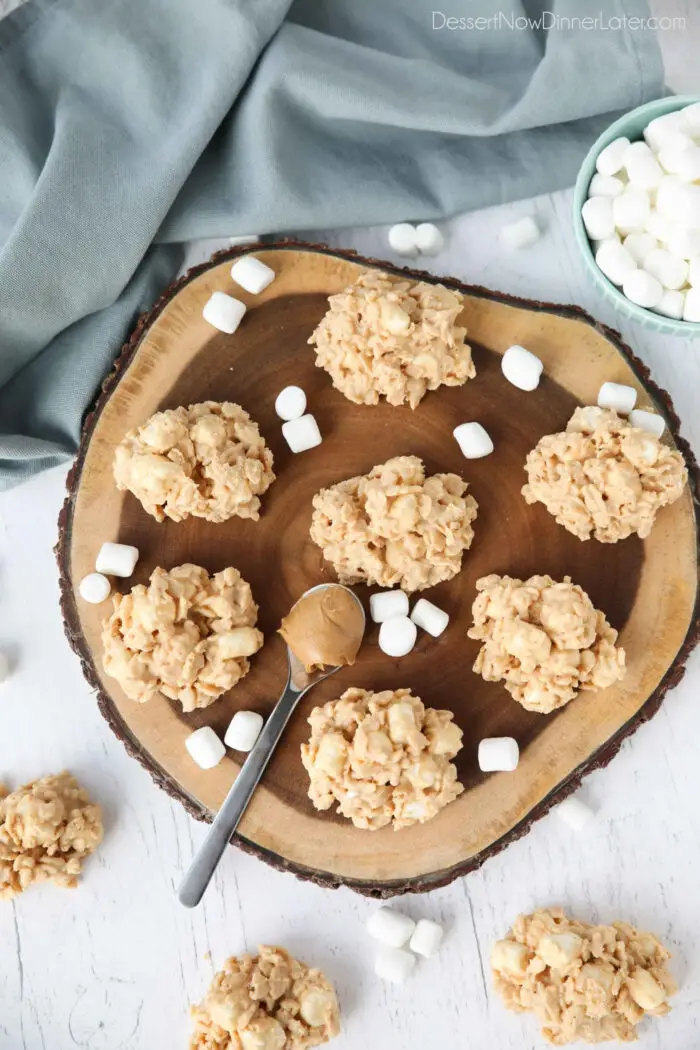 Top view of no bake avalanche cookies on a wood board with a spoon of peanut butter and mini marshmallows.