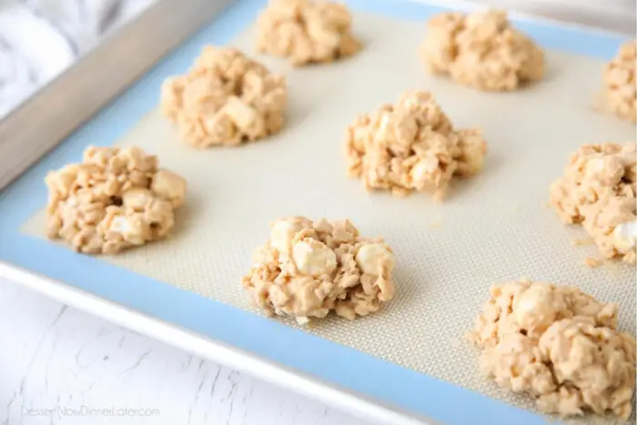 Dollops of peanut butter rice krispie treat cookies on sheet tray.