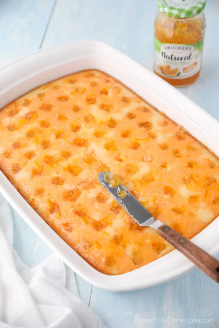 Spreading orange marmalade onto orange jello cake.