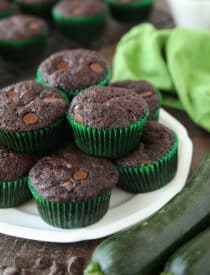 Plate full of chocolate zucchini muffins with chocolate chips.