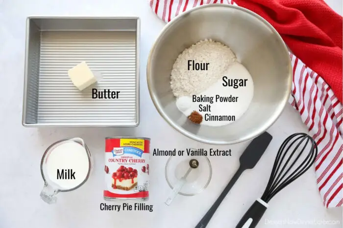 Ingredients for easy cherry cobbler: Butter, flour, sugar, baking powder, salt, cinnamon, milk, almond or vanilla extract, and cherry pie filling.