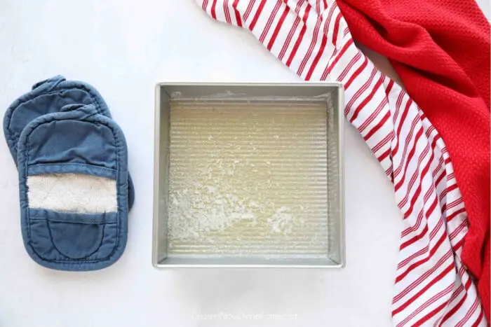 Melted butter in a square baking dish.