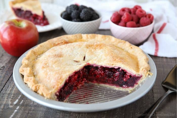 Razzleberry Pie with raspberries and blackberries in a pie tin, with a couple of slices taken out.