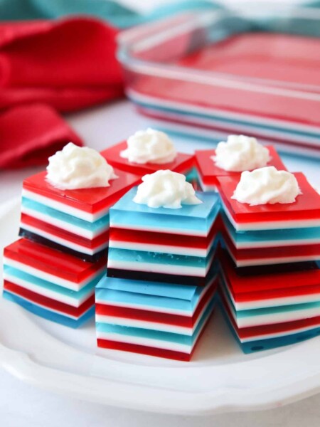 Red white and blue layered jello jigglers with whipped cream on top.