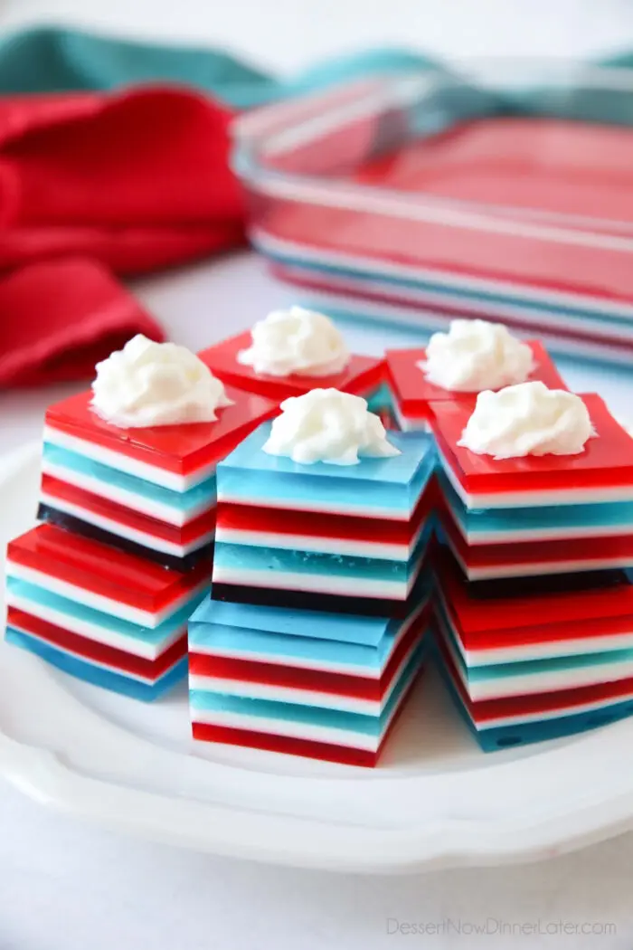 Red white and blue layered jello jigglers with whipped cream on top.