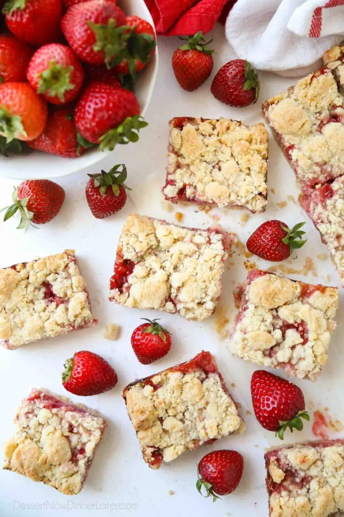 Strawberry Crumb Bars cut into squares with fresh strawberries.