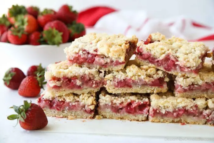 Strawberry Crumb Bars stacked on top of parchment paper.