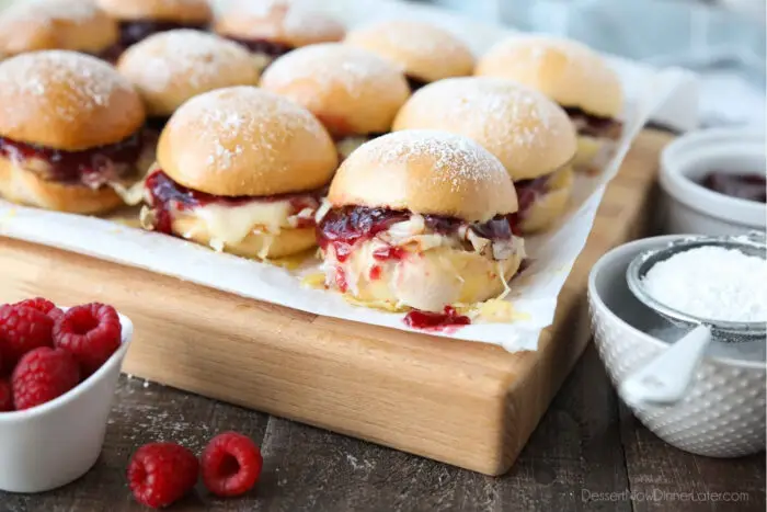 Warm Monte Cristo Sliders on top of a cutting board.