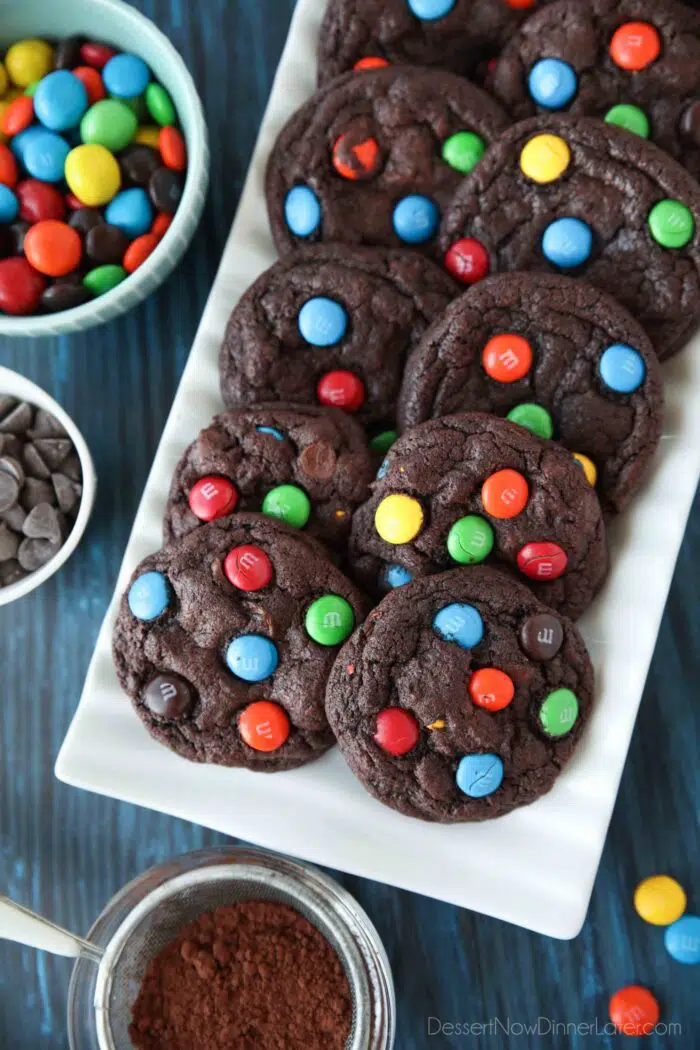 Serving platter of chocolate cookies with M&M's and chocolate chips inside.