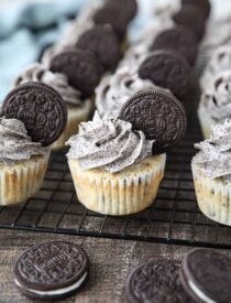 Closeup of vanilla cupcakes with Oreos inside and Oreo frosting on top with an Oreo cookie garnish.