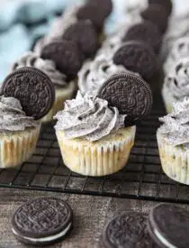 Closeup of vanilla cupcakes with Oreos inside and Oreo frosting on top with an Oreo cookie garnish.