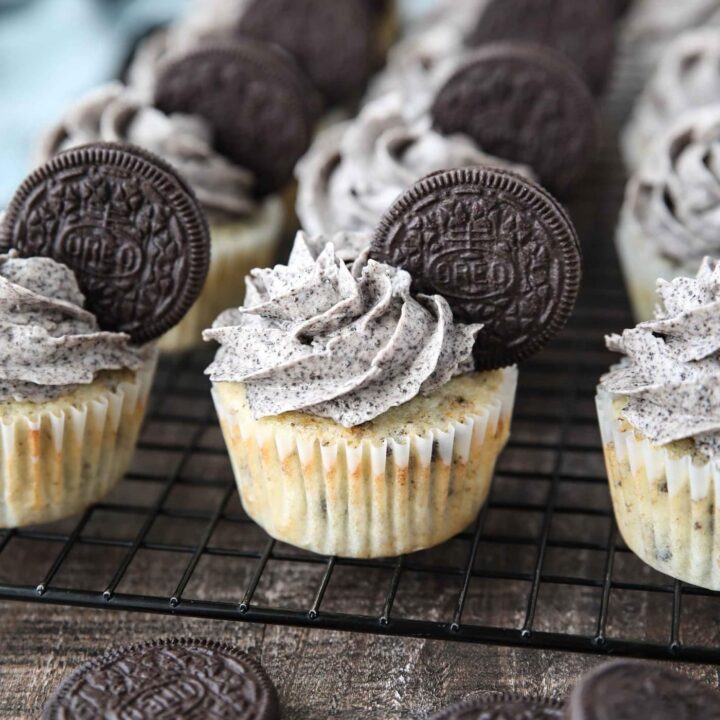 Closeup of vanilla cupcakes with Oreos inside and Oreo frosting on top with an Oreo cookie garnish.