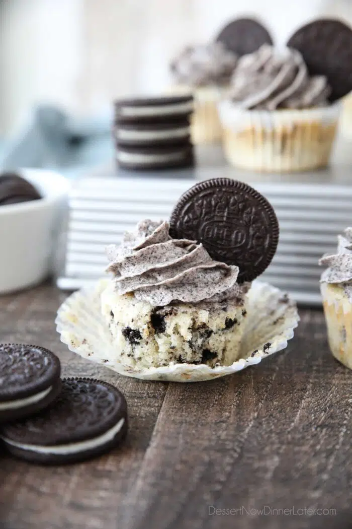 The sides of a cupcake wrapper pulled down from a cookies and cream cupcake.