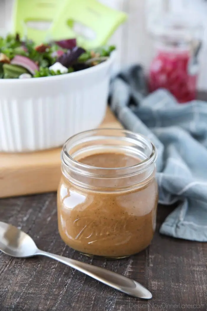 Mason jar with creamy balsamic dressing and a spoon.