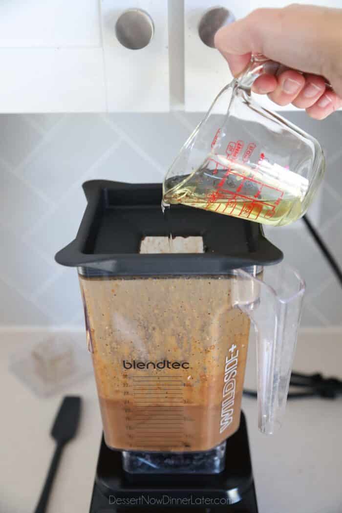 Slowly adding oil to blender of ingredients for balsamic dressing.